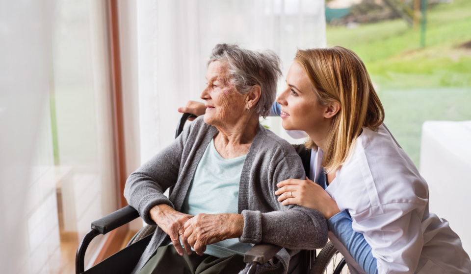 Health visitor and a senior woman during home visit. A nurse talking to an elderly woman in an wheelchair.